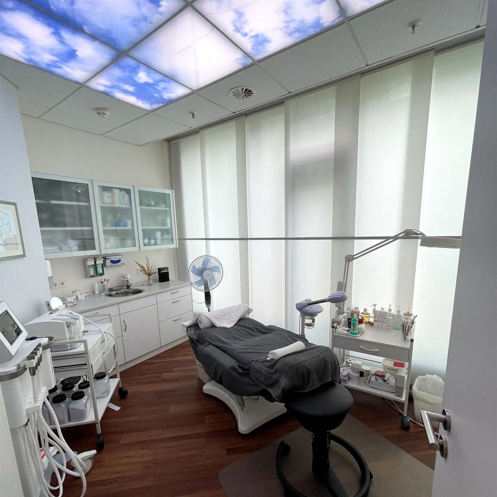 Ein modernes, helles Untersuchungszimmer mit Krankenhausbett und medizinischer Ausrüstung.